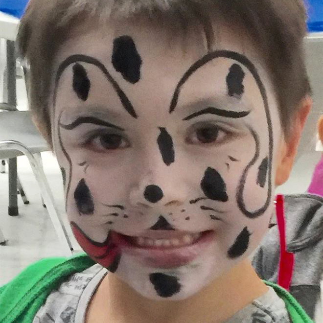 Boy's face painted like Dalmatian
